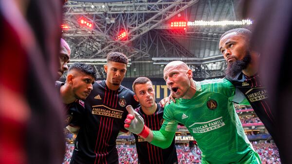 Atlanta United starting 11 - led by goalkeeper Brad Guzan (in green) - huddle before match against Nashville Saturday, Aug. 28, 2021, at Mercedes-Benz Stadium in Atlanta. (Jacob Gonzalez/Atlanta United)