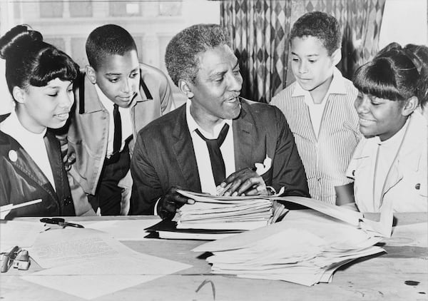 Civil rights leader Bayard Rustin (center) speaks with children before a demonstration in 1964. CONTRIBUTED BY LIBRARY OF CONGRESS