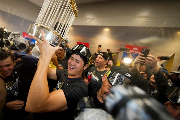 Los Angeles Dodgers' Shohei Ohtani celebrates in the locker room after their win against the New York Yankees in Game 5 to win the baseball World Series, Thursday, Oct. 31, 2024, in New York. (AP Photo/Ashley Landis)