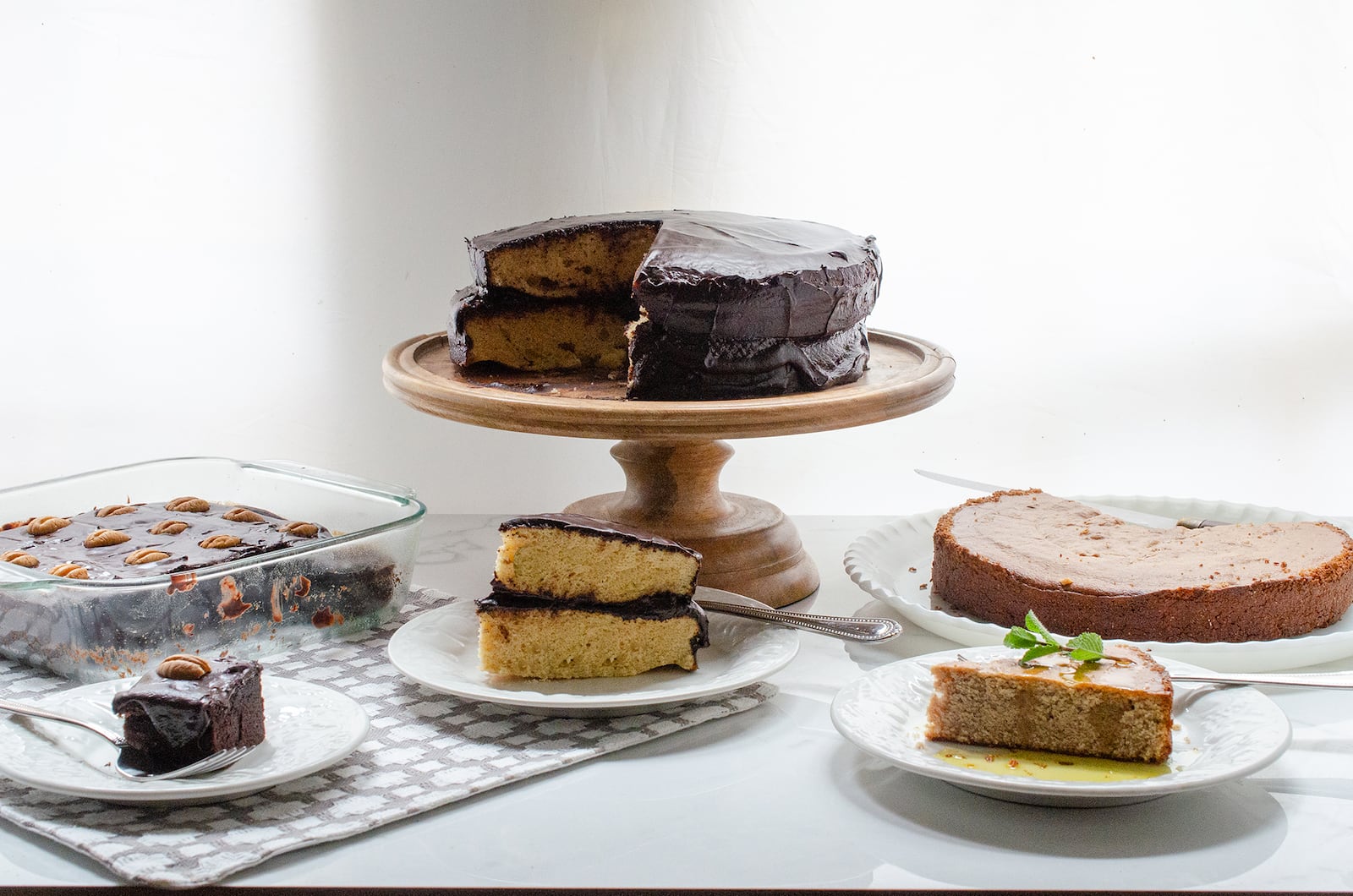 Trio of blender baking recipes: Gluten Free Chocolate Snack Cake and Yellow Blender Cake, both topped by Old Fashioned Chocolate Frosting, and Vegan Lemon Olive Oil Cornmeal Cake 
(Virginia Willis for The Atlanta Journal-Constitution)