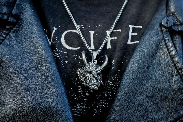 A member of The Temple of Satan: Satanists and Luciferians of Chile, wears a pendant depicting Satan during a ceremony at the General Cemetery in Santiago, Saturday, Sept. 14, 2024. (AP Photo/Esteban Felix)