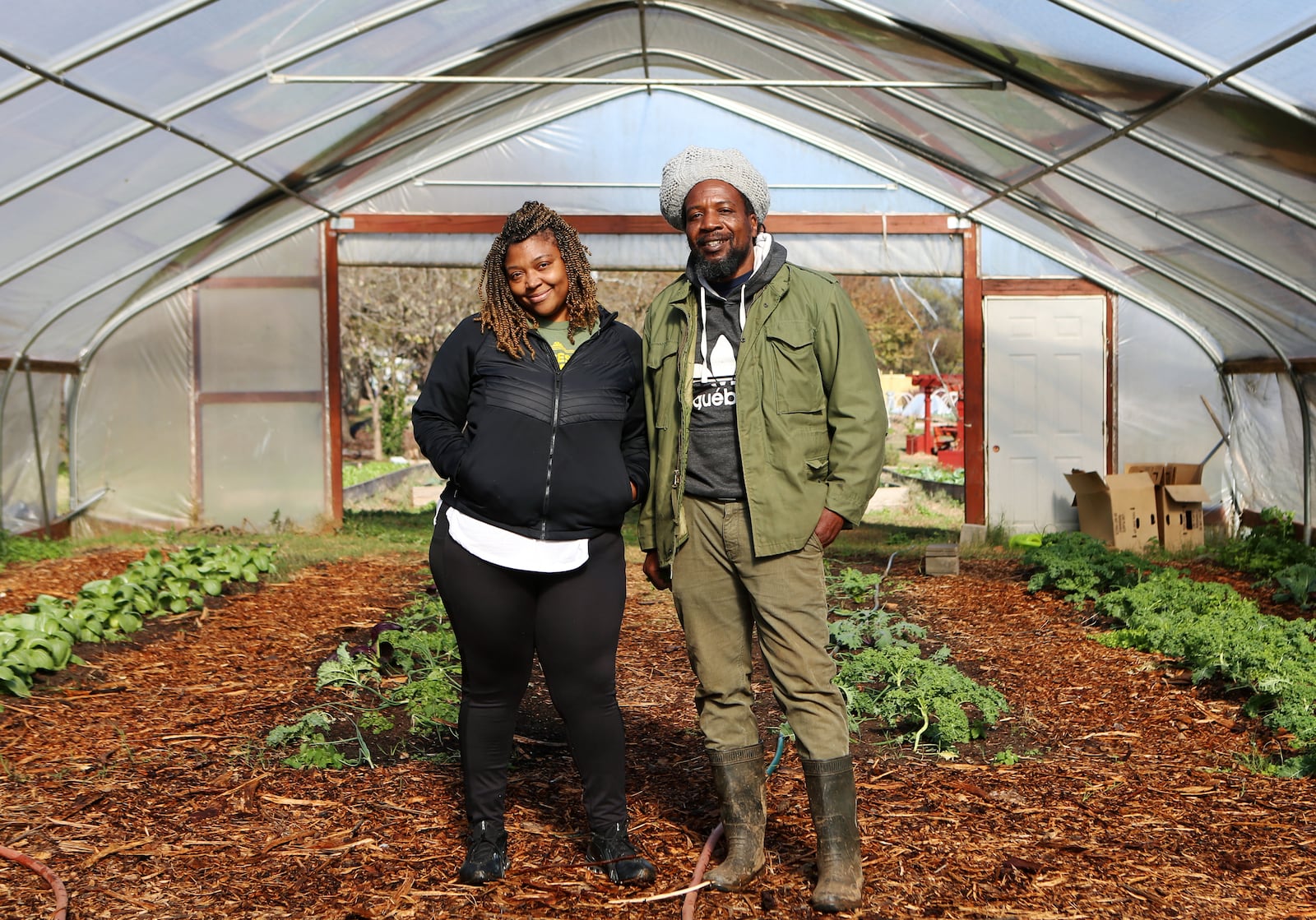 Otis Garrison (right), farm manager at Truly Living Well Farm, and Ivory Flemister (left), media manager at Truly Living Well Farm, stand in the greenhouse at Truly Living Well Farm in Atlanta. CHRISTINA MATACOTTA FOR THE ATLANTA JOURNAL-CONSTITUTION