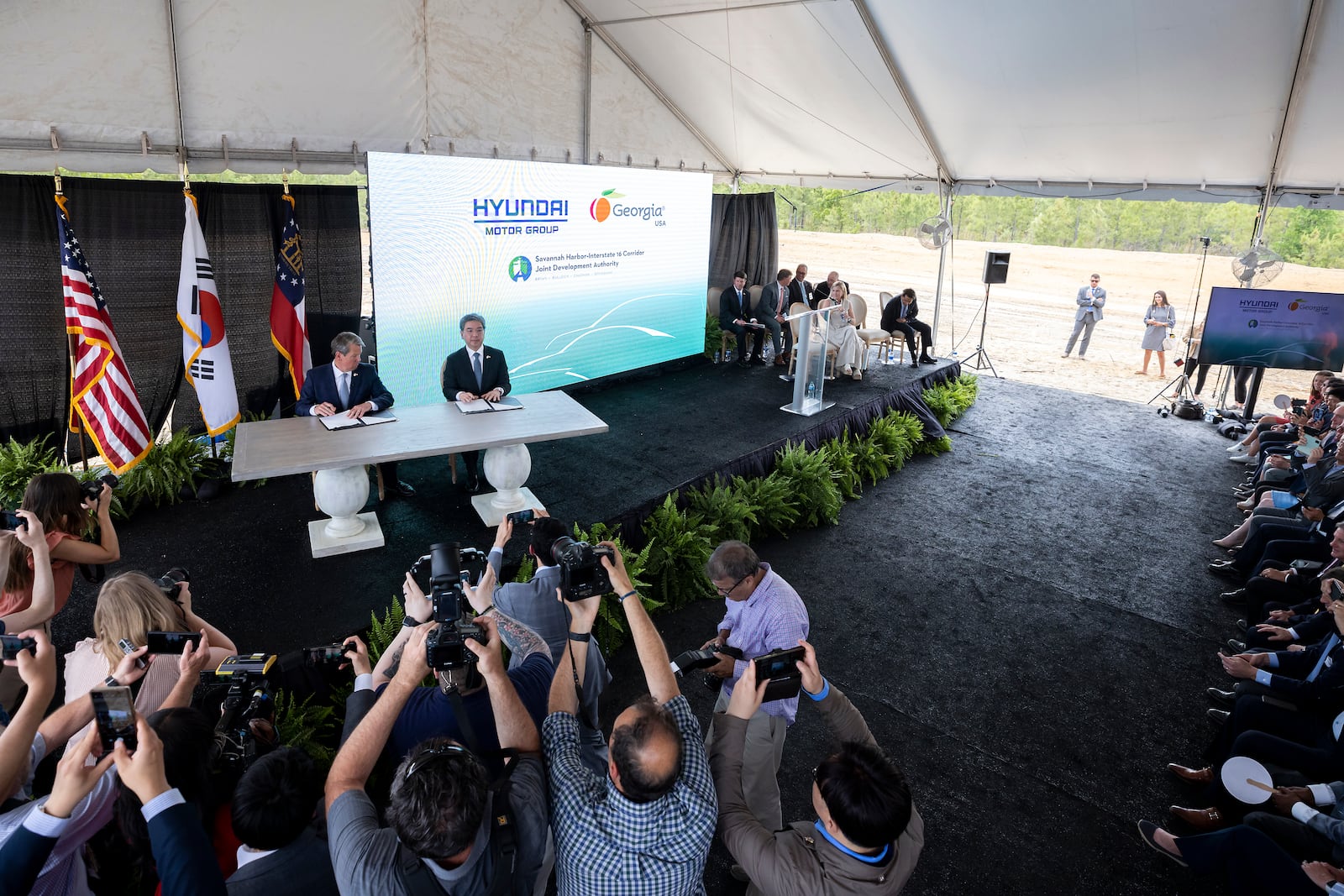 ELLABELL, GEORGIA - MAY 20, 2022:  Governor Brian P. Kemp, center left, and 
Hyundai Motor Group President and CEO Jae Hoon Chang, center right, sign a ceremonial document at the announcement that the South Korean automotive giant is building an electric vehicle plant in Ellabell, Ga. Hyundai plans to build a multi-billion-dollar electric vehicle assembly and battery plant outside of Savannah that eventually could employ about 8,100 workers. (AJC Photo/Stephen B. Morton)