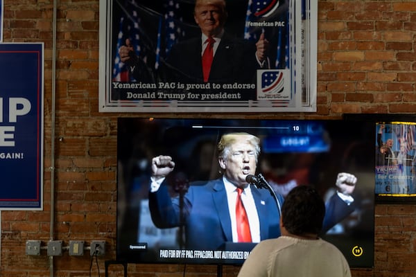 Arif Armanjisan watches an advertisement for Republican presidential nominee former President Donald Trump at his campaign office the night before the general election Monday, Nov. 4, 2024, in Hamtramck, Mich. (AP Photo/David Goldman)