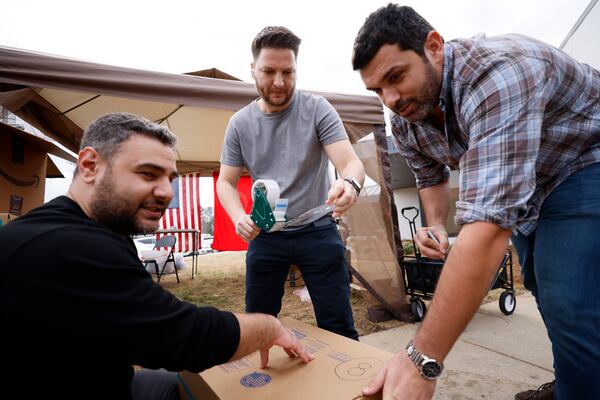 L-r,  Volunteers Ali Bekem, Burhan Öztürkçe, and Erman Dincer, work sealing the box with donations during the Turkey relief drive organized by various organizations of the Turkey community in the metro Atlanta area. Miguel Martinez / miguel.martinezjimenez@ajc.com