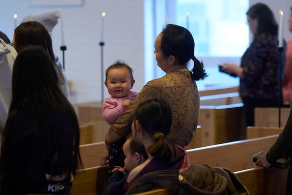 A baby is held by her mother as they attend a religious service at Hans Egede Church in Nuuk, Greenland, Sunday, Feb. 16, 2025. (AP Photo/Emilio Morenatti)