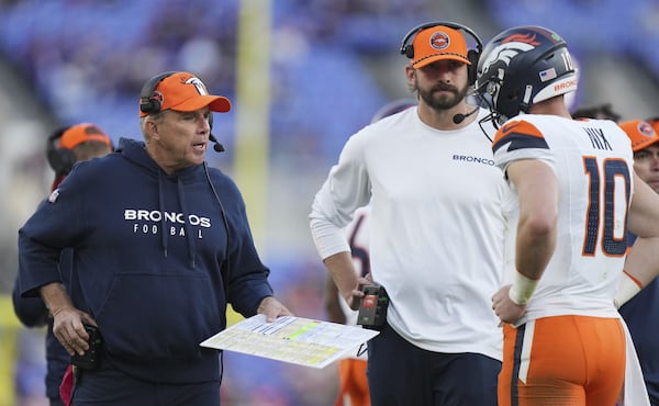 Broncos head coach Sean Payton (left) confers with quarterback Bo Nix as quarterbacks coach Davis Webb listens in during a timeout in the second half of the Nov. 3 game against the Baltimore Ravens. (AP Photo/Stephanie Scarbrough)