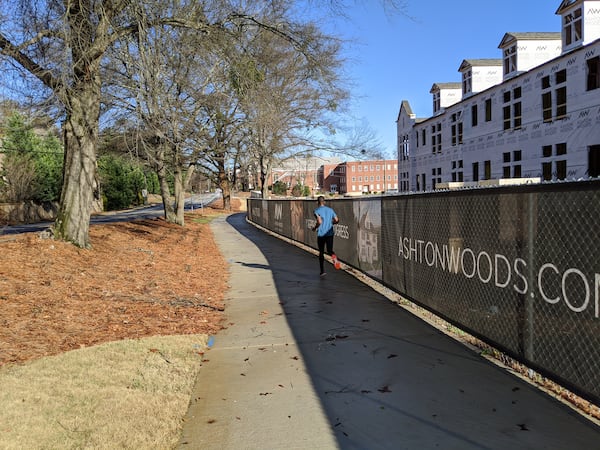 Brookhaven is building its path network one property at a time by requiring developers to either build segments in front of their projects or pay into a fund, depending on whether they are building along a planned route. A jogger is on this new stretch on North Druid Hills Road on Dec. 24, 2019, near Briarwood Road. It’s on the route the city will use to connect the Peachtree Creek Greenway at Briarwood to a MARTA station on Peachtree Road. TY TAGAMI / TY.TAGAMI@AJC.COM