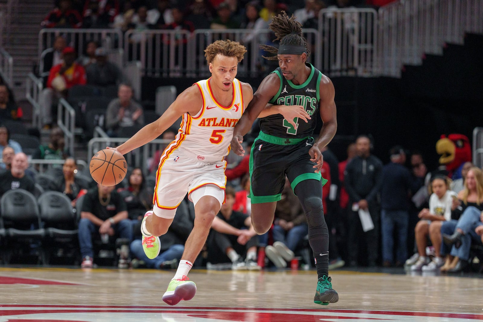 Atlanta Hawks guard Dyson Daniels (5) dribbles the ball while guarded by Boston Celtics guard Jrue Holiday (4) during the first half of an NBA basketball game, Monday, Nov. 4, 2024, in Atlanta. (AP Photo/Jason Allen)