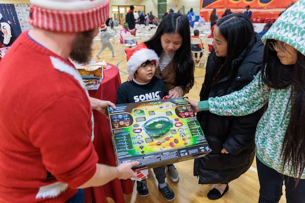 Uriah Her, 8, displays a present he received at the Wade Walker Park Family YMCA in Stone Mountain on Wednesday, December 21, 2022 . The event was put on by rapper 21 Savage’s Leading By Example foundation. (Arvin Temkar / arvin.temkar@ajc.com)