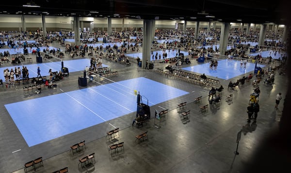 Dozens of volleyball courts covered a convention hall at the Georgia World Congress Center during the Lil’ Big South girls volleyball tournament in January. COVID safety precautions included a mask requirement and spaced seating. (Ben Gray for The Atlanta Journal-Constitution)