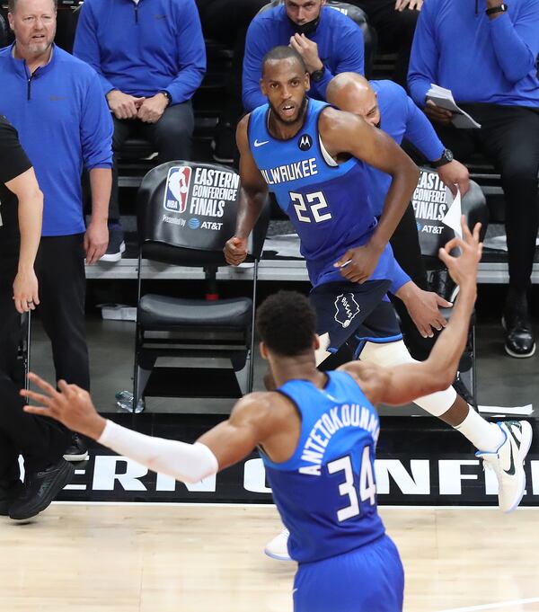 Milwaukee Bucks teammate Giannis Antetokounmpo (foreground) signals the three-point shot made by forward Khris Middleton  (background) over the Atlanta Hawks in the final minutes of Game 3 of the Eastern Conference finals Sunday, June 27, 2021, at State Farm Arena in Atlanta. (Curtis Compton / Curtis.Compton@ajc.com)