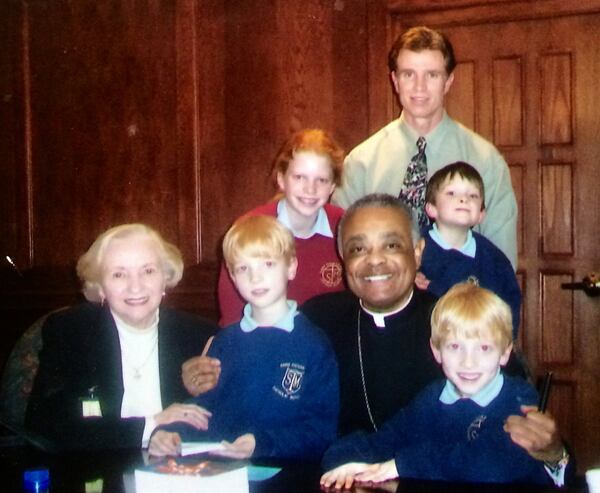 Archbishop Wilton Gregory in 2005 with Bill Torpy, Torpy’s mother and Torpy’s children. From left: Helen Torpy, Liam, Emma, the archbishop, Torpy, Michael and Fred. 