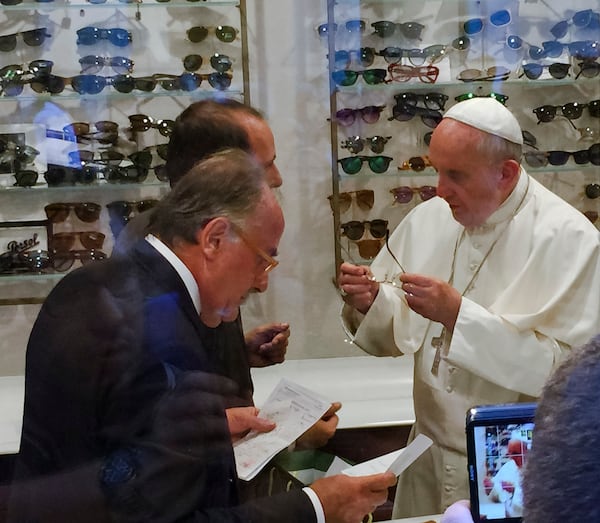 FILE - In this Sept. 3, 2015 file photo, Pope Francis tries on a pair of spectacles in an eyeglass store in via del Babuino, in central Rome. (Daniel Soehne via AP, File)