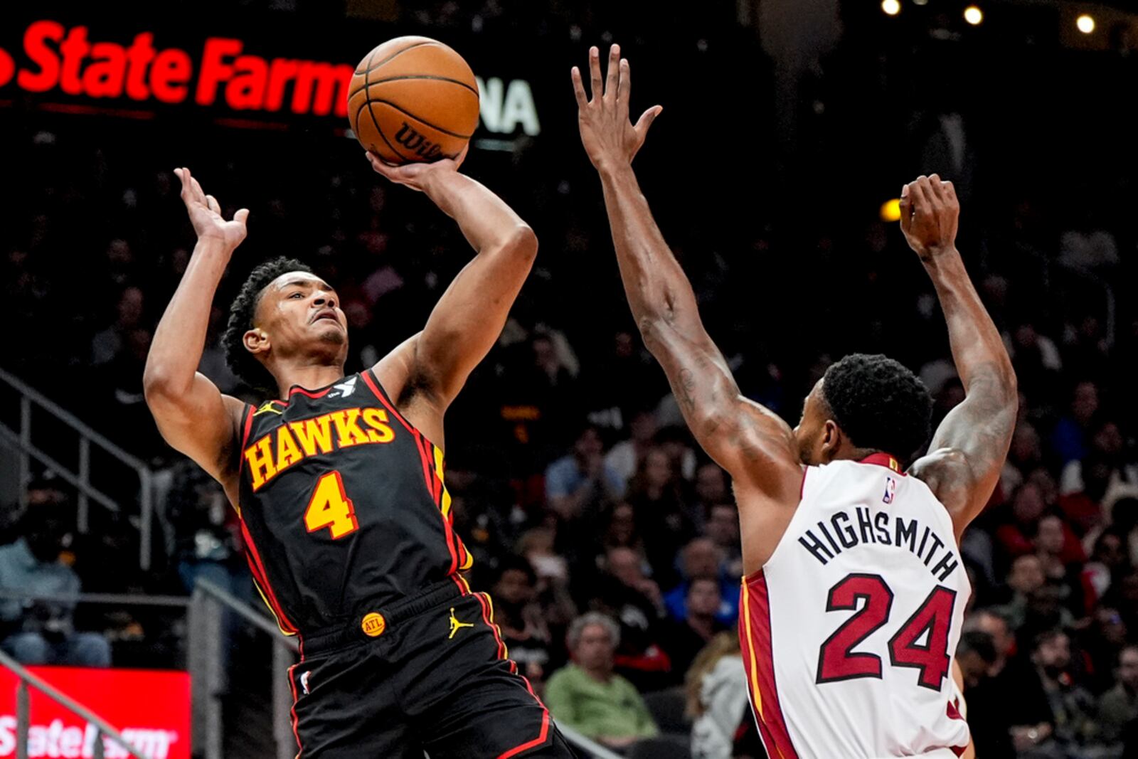 Atlanta Hawks guard Kobe Bufkin (4) shoots against Miami Heat forward Haywood Highsmith (24) during the first half of an NBA basketball game, Tuesday, April 9, 2024, in Atlanta. (AP Photo/Mike Stewart)