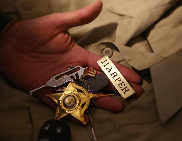 Putnam County Deputy Sgt. John Harper turned in his uniform and badge to Sheriff Howard Sills this month, working his final shift the week before Thanksgiving. (Curtis Compton / Curtis.Compton@ajc.com)