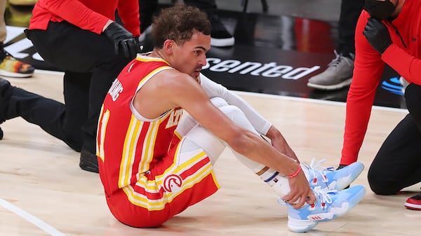 Hawks guard Trae Young is tended to on the floor with a possible ankle injury during the third quarter of Game 3 of the Eastern Conference finals against the Milwaukee Bucks Sunday, June 27, 2021, in Atlanta. (Curtis Compton / Curtis.Compton@ajc.com)