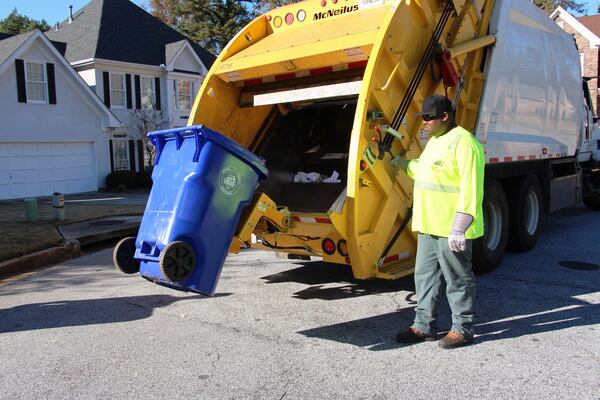 A DeKalb County sanitation worker empties a trash bin. SPECIAL PHOTO