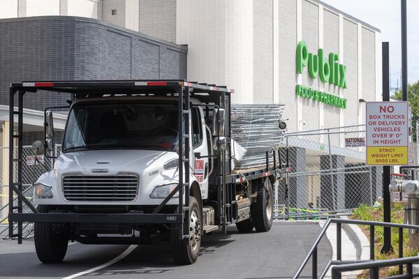 Workers put up fences around the parking deck that collapsed at the Summerhill Publix on Saturday, Sep. 2, 2023,  (Steve Schaefer/steve.schaefer@ajc.com)