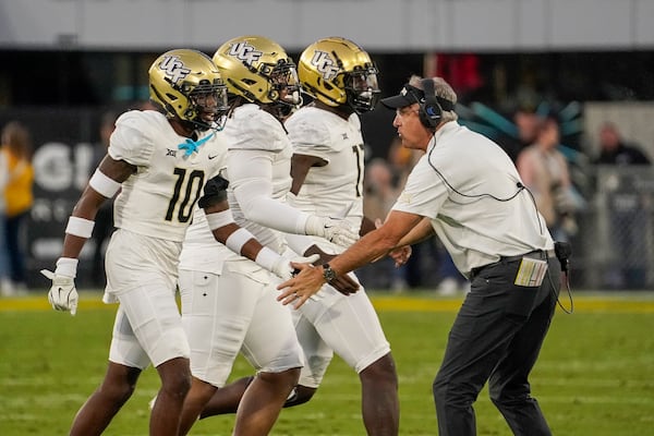 Central Florida head coach Guz Malzahn, right, congratulates his defense after stopping Arizona State on a fourth down conversion attempt during the first half of an NCAA college football game Saturday, Nov. 9, 2024, in Tempe, Ariz. (AP Photo/Darryl Webb)