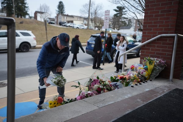 People place flowers in front of the West York Police Department after a police officer was killed responding to a shooting at UPMC Memorial Hospital in York, Pa. on Saturday, Feb. 22, 2025. (AP Photo/Matt Rourke)