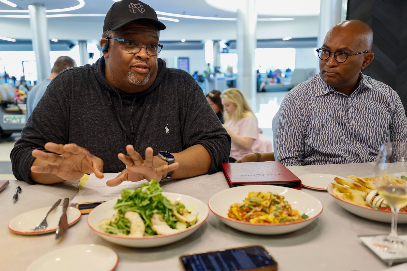 National Southern chef Duane Nutter (left), who seats beside Reggie Washington as they speak to AJC  Editor Kelly Yamanouchi about the food items they provided for Vino Volo at the new location in Terminal T at Hartsfield-Jackson Atlanta International Airport on Wednesday, May 1, 2024.
(Miguel Martinez / AJC)