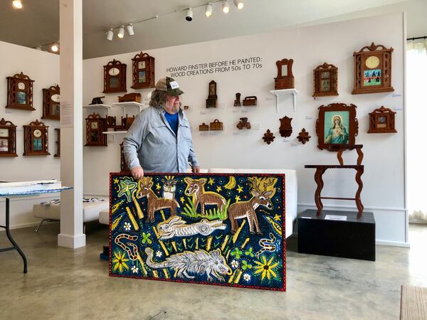 Howard Finster's longtime friend and fellow artist Peter Loose stands behind his own artwork. Loose's art will be featured in this year's Finster Fest. Photo: Courtesy of Peter Loose