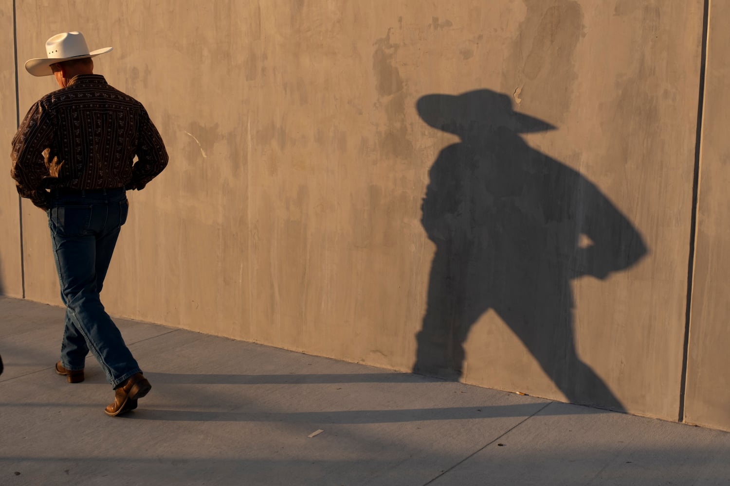 The late afternoon sun casts a man’s shadow before the start of a rally for former President Donald Trump in Macon on Sunday, Nov. 3, 2024.   Ben Gray for the Atlanta Journal-Constitution