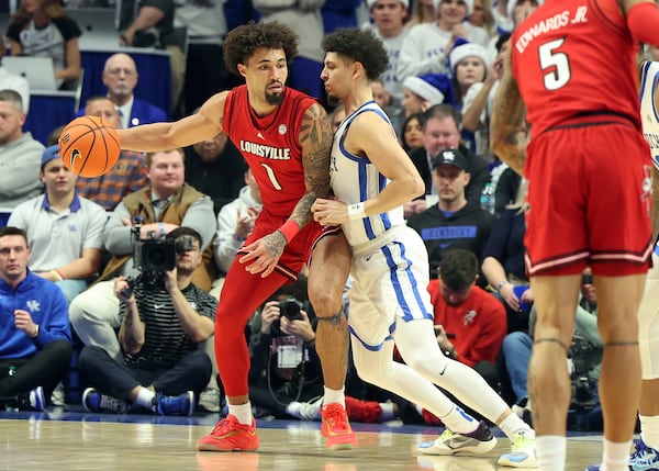 Louisville's J'Vonne Hadley (1) looks for an opening against Kentucky's Koby Brea, center right, during the first half of an NCAA college basketball game in Lexington, Ky., Saturday, Dec. 14, 2024. (AP Photo/James Crisp)