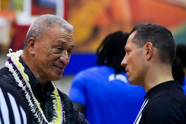 Maui County mayor Richard Bissen, left, talks with an official before an NCAA college basketball game between UConn and Memphis at the Maui Invitational Monday, Nov. 25, 2024, in Lahaina, Hawaii. (AP Photo/Lindsey Wasson)