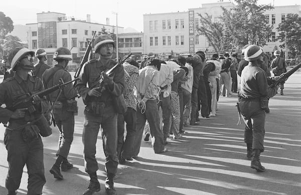 FILE - Armed South Korean government martial law troops guard captured rebels in Gwangju (Kwangju), South Korea, on May 27, 1980. The rebels were rounded up following the government's recapture by the riot-battered city. (AP Photo/Sadayuki Mikami, File)