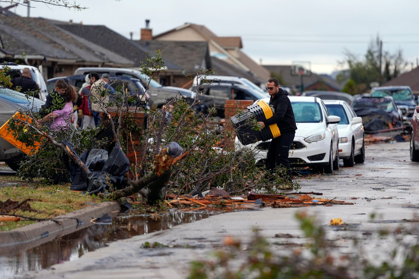 A person collects items from a damaged home on Stonewood Drive after a tornado moved through the area in Oklahoma City, Sunday, Nov. 3, 2024. (Bryan Terry/The Oklahoman via AP)