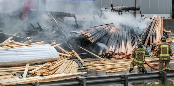 The lumber from the wrecked truck spilled onto the interstate and also went up in flames, authorities said. (John Spink / John.Spink@ajc.com)

