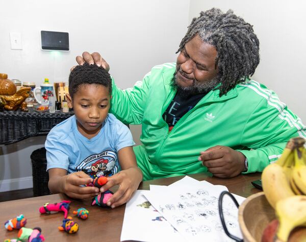 Michael Glenn with his son at their Decatur home. 
