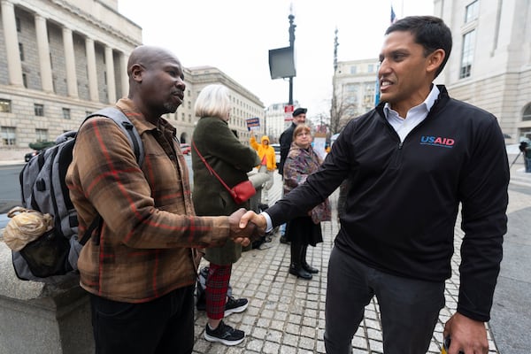 Rajiv Shah, former United States Agency for International Development (USAID) Administrator, right, talks to USAID worker Shaun Douglas, who has just been fired, outside USAID's headquarters in Washington, Thursday, Feb. 27, 2025. (AP Photo/Manuel Balce Ceneta)