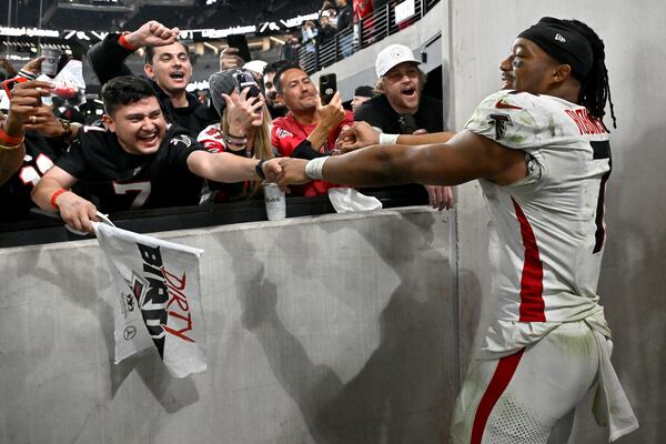 Atlanta Falcons running back Bijan Robinson (7) greets fans after an NFL football game against the Las Vegas Raiders on Monday, Dec. 16, 2024, in Las Vegas. (AP Photo/David Becker)