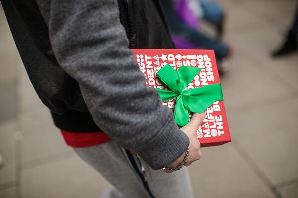 A man carries a gift-wrapped box on Christmas Eve 2016. (Photo by Jack Taylor/Getty Images)