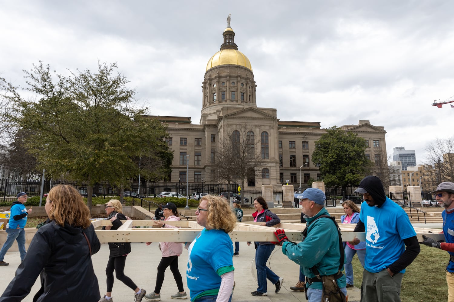 Habitat for Humanity volunteers take down the frame of a home built at Liberty Plaza, outside the Capitol, in Atlanta on Wednesday, March 5, 2025. The frame will be transported and used to house a family. (Arvin Temkar / AJC)