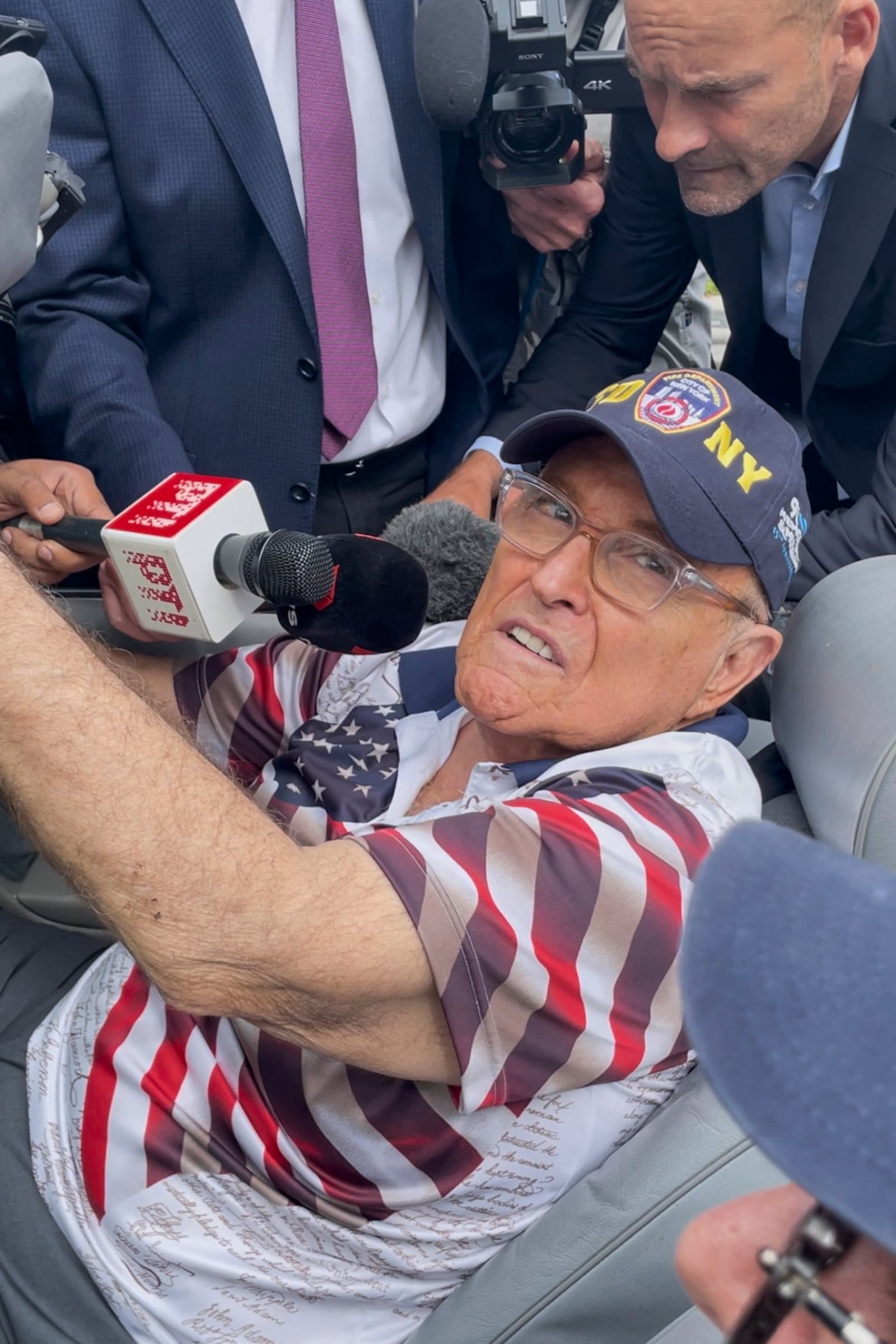 This photo provided by the Financial Times shows Rudy Giuliani in the passenger seat of a Mercedes convertible at the same polling place where Donald Trump cast his ballot on Election Day, Tuesday, Nov. 5, 2024, in Palm Beach, Fla. (Alex Rogers/Financial Times via AP)