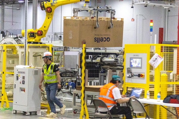 Workers fine-tune the packaging and shipment portion of the automated system at the Qcells module production facility in Cartersville on Tuesday, April 2, 2024.  (Steve Schaefer/steve.schaefer@ajc.com)