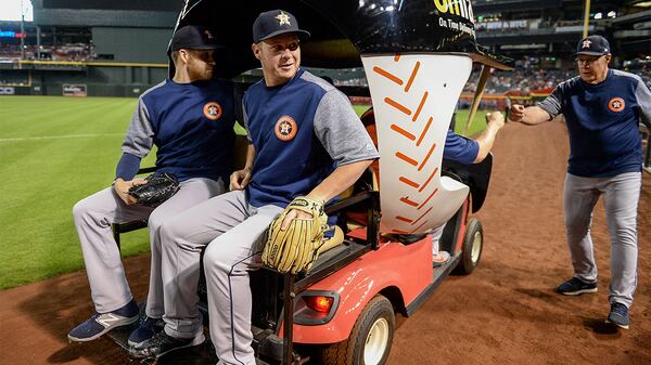 Houston's Collin McHugh (left) and Brad Peacock test out the Arizona Diamondback's bullpen cart before a game against the Arizona Diamondbacks at Chase Field.