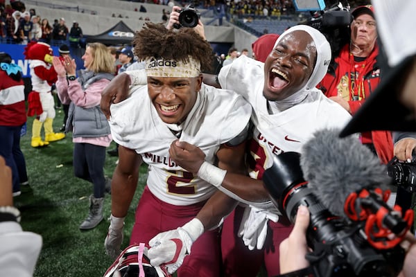 Mill Creek defensive back Caleb Downs, left, and running back Cam Robinson celebrates during the closing minutes of their 70-35 win against Carrollton in the GHSA Class 7A finals, at Center Parc Stadium, Saturday, Dec. 10, 2022, in Atlanta. (Jason Getz / Jason.Getz@ajc.com)