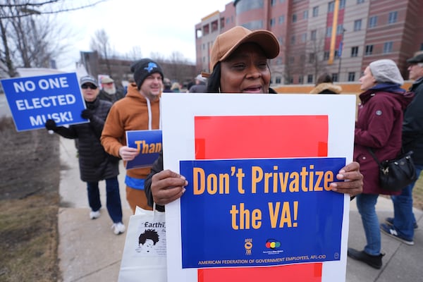 Protesters walk outside the John D. Dingell Veterans Affairs Medical Center in Detroit, Friday, Feb. 28, 2025. (AP Photo/Paul Sancya)