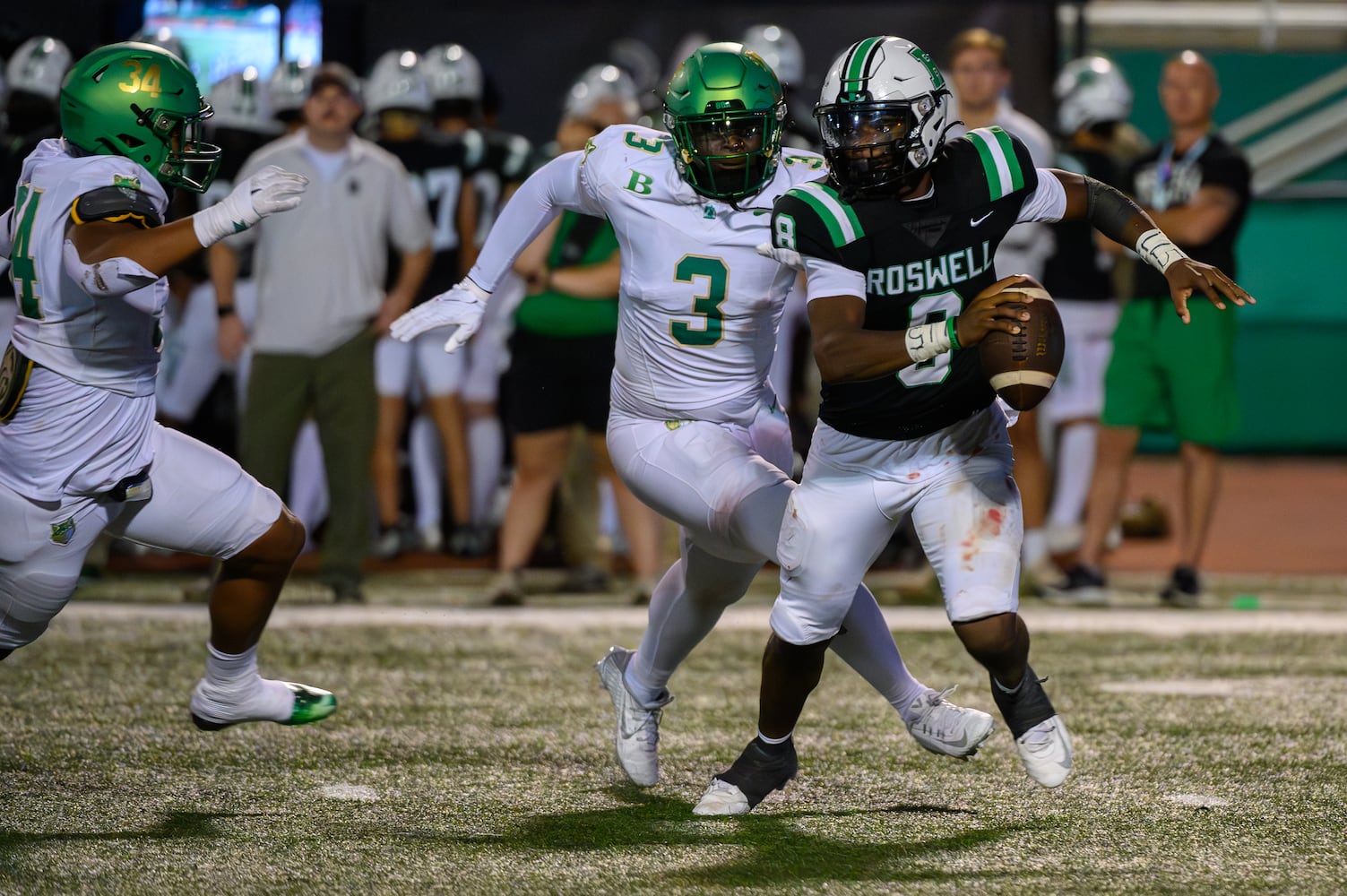 Roswell’s quarterback, Trey Smith, eludes Buford defenders. (Jamie Spaar for the Atlanta Journal Constitution)