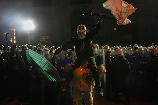 Protesters stand in front of riot police as they protest against the arrest of Istanbul's Mayor Ekrem Imamoglu, in Istanbul, Turkey, Saturday, March 22, 2025. (AP Photo/Francisco Seco)