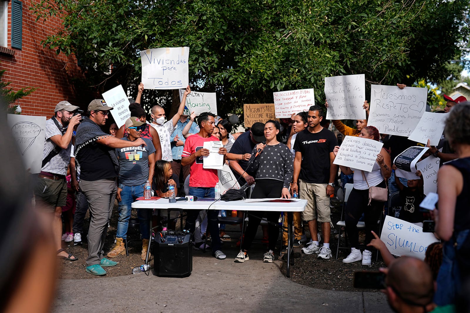 FILE - Juan Carlos Jimenez, center left, and Geraldine Massa speak during a rally by the East Colfax Community Collective to address chronic problems in the apartment buildings occupied by people displaced from their home countries in central and South America, Tuesday, Sept. 3, 2024, in Aurora, Colo. (AP Photo/David Zalubowski, File)