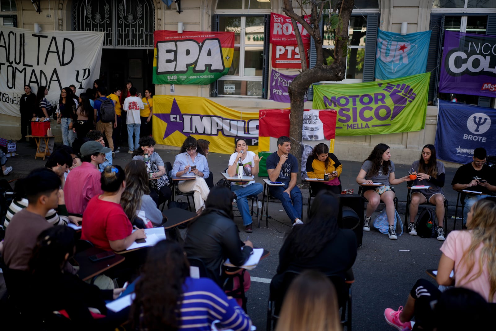 Students hold class in the middle of a street outside the Faculty of Psychology to protest President Javier Milei's veto of higher funding for public universities, in Buenos Aires, Argentina, Wednesday, Oct. 16, 2024. (AP Photo/Natacha Pisarenko)