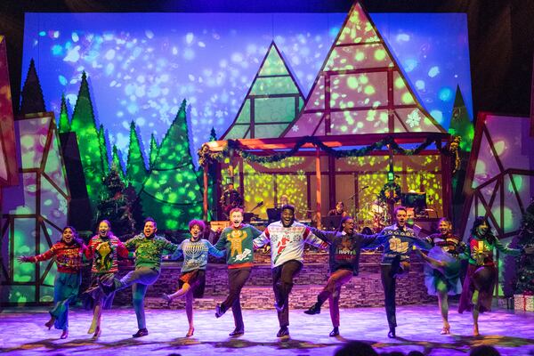 The full cast of “Christmas Canteen” dances wearing holiday sweaters.