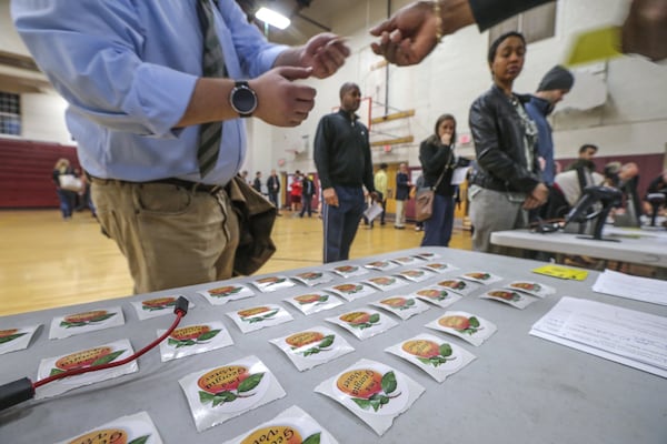 Atlanta: Voting stickers are handed out at Henry W. Grady High School in Atlanta as Georgians cast ballots in the state’s Mar. 1, 2016 presidential primary. A new poll commissioned by The Atlanta Journal-Constitution heading into November’s general election found that most Georgians think the next president should make race relations a priority. JOHN SPINK / JSPINK@AJC.COM