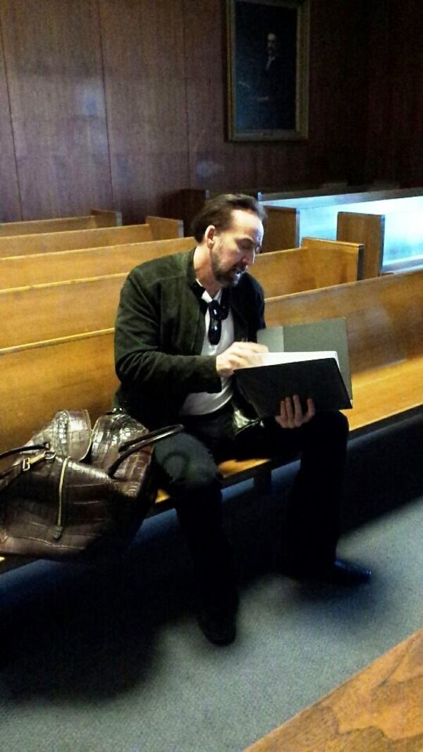 Nicolas Cage goes over the script on the set of "Vengeance: A Love Story." It filmed recently at the Fulton County Courthouse. Photo: Bob Giordano